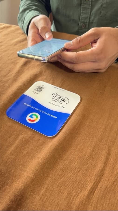 Eine Google-Bewertungskarte auf dem Tresen, mit dem Handy angetippt (5)
